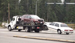 A tow truck towing a car on the road